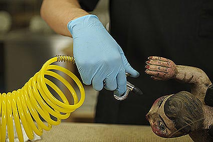 a technician cleaning a small angel statue damaged in a residential house fire.